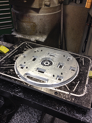 Photo of the front plate after completing all of the machining processes.  The part includes a handle section to lift the assembly, as well as a modular ports to allow for two internal components to be stacked in series.
